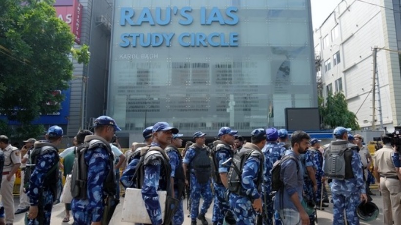 Security personnel stand guard near a UPSC exam coaching centre after three civil services aspirants died when the basement of the coaching centre was flooded following heavy rain in New Delhi, on Sunday.