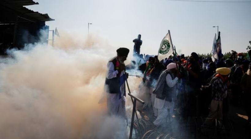 Farmers stand next to the barricades at Shambhu border after commencing their foot march to Delhi